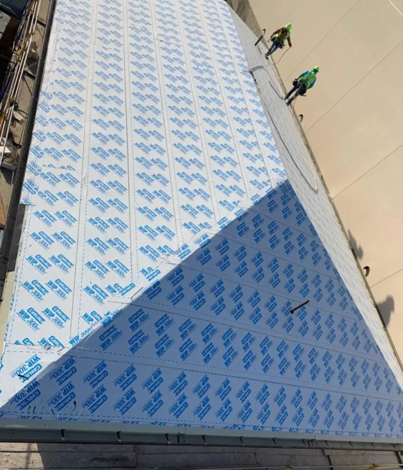 Professional roofers installing underlayment on a metal roof in Milton